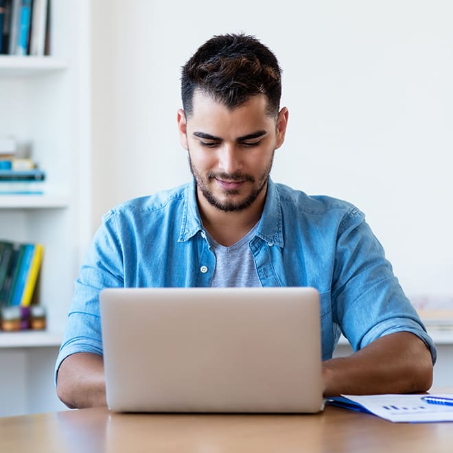 HomePage-Blog A man sitting at a table with a laptop.