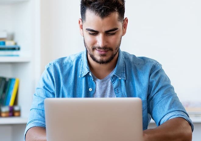 A man sitting at a table with a laptop.