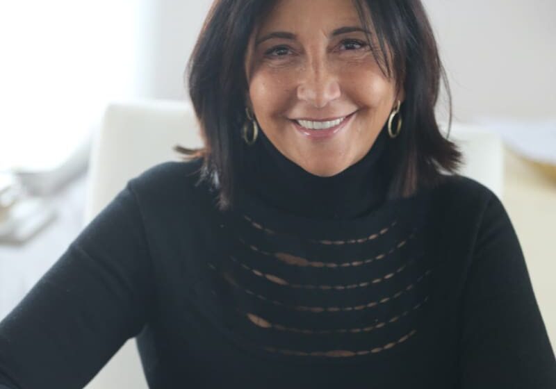 Woman smiling in a black sweater.