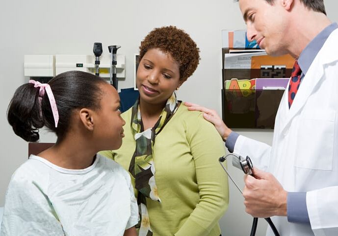 A woman and two men are talking to a young girl.